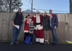 Picture of group standing with Santa outside.