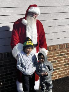 Picture of Santa standing with children.